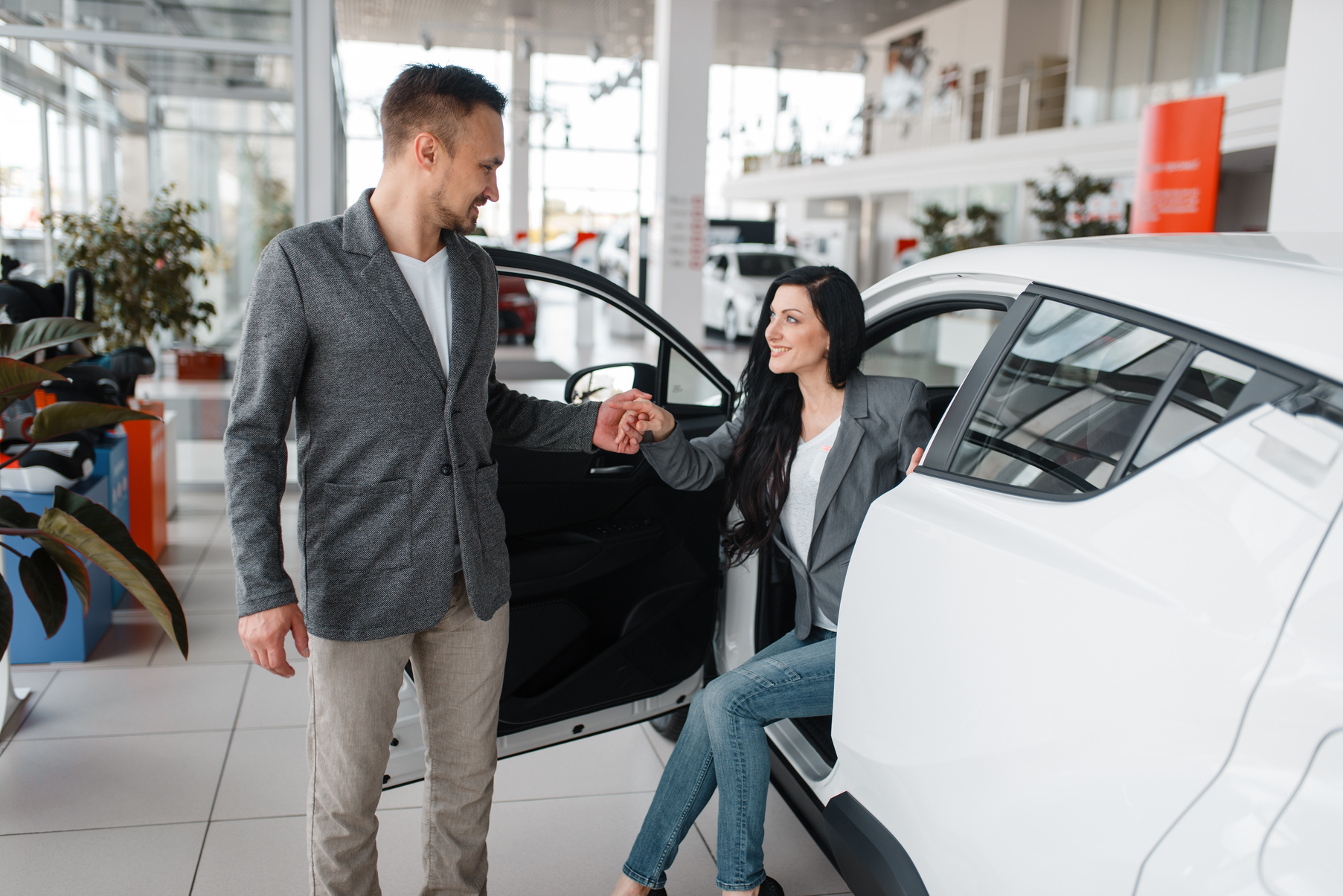 Man and Woman Buying New Car in Showroom